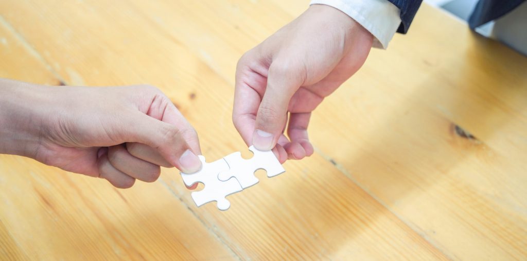 person holding white jigsaw puzzle piece