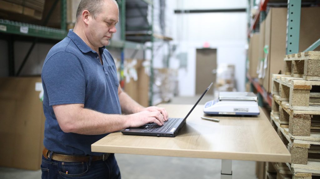 a person in a warehouse typing on a computer