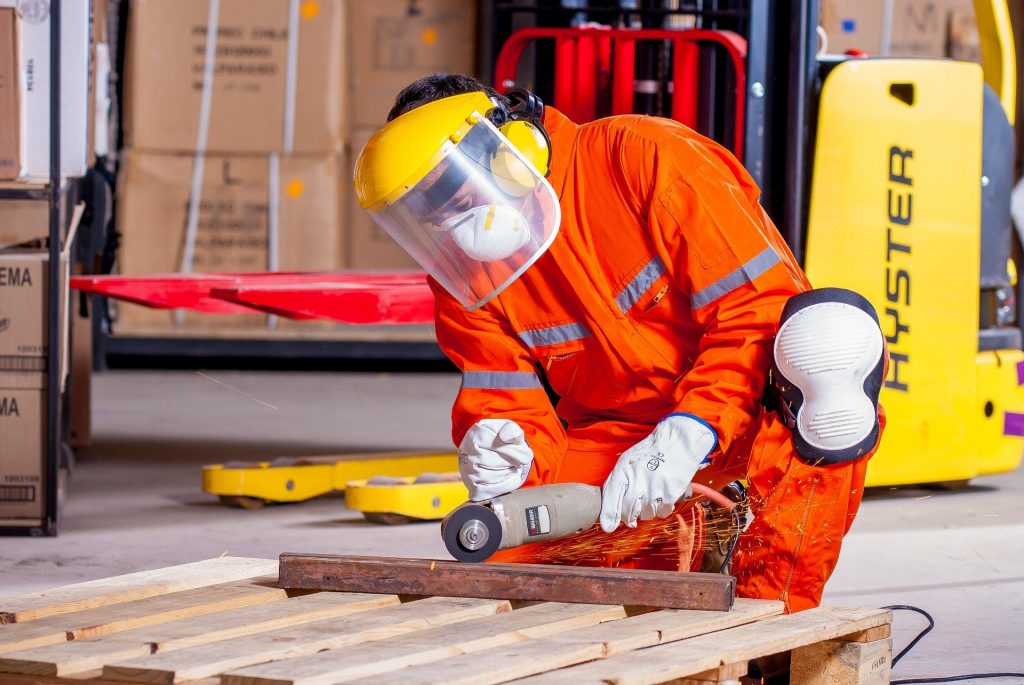 an industrial worker using a tool on a piece of metal