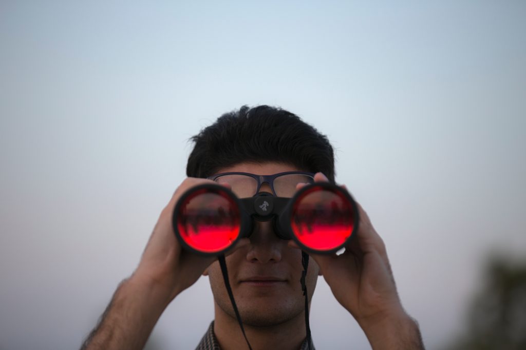 a man looking through a pair of binoculars