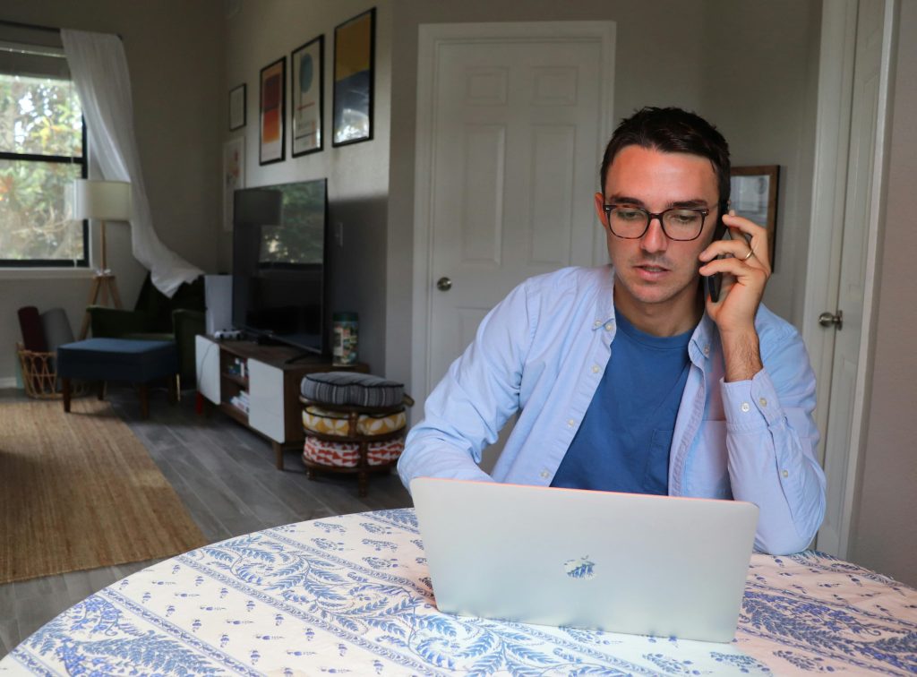 a person working from home - sitting at a kitchen table and using a laptop