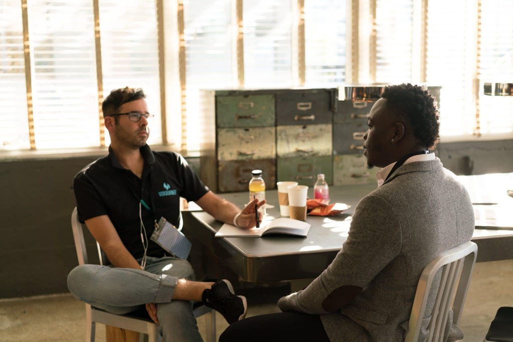 two men in business casual attire having a discussion while seated