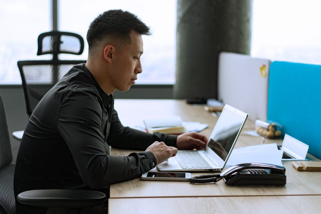 Man looking at a laptop on a desk