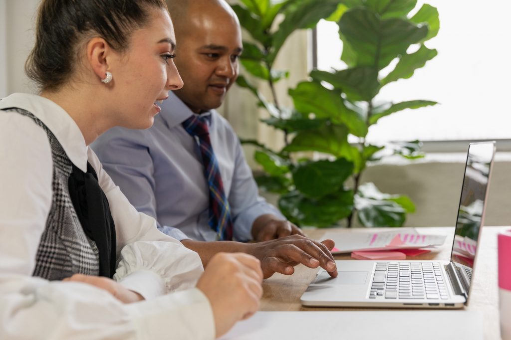 a man and a woman sitting at a computer talking