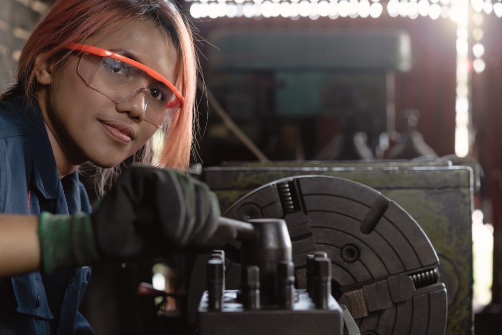 female mechanical engineer working on industrial factory machinery